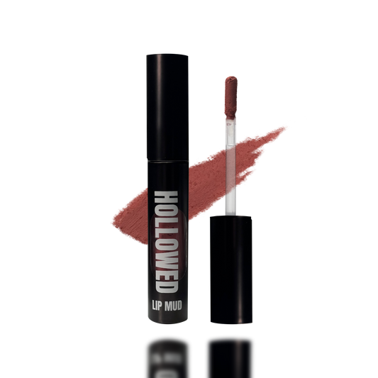 LIP MUD IN BLACK PACKAGING WITH A WINDOW TO SEE COLOR AND NEXT TO THE PRODUCT'S WAND. COLOR SWATCH BEHIND PRODUCT OF A DARK MAUVE PINK COLOR